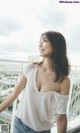 A woman standing on top of a balcony next to a railing.