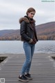 A woman standing on a wooden dock near a body of water.