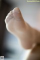 A close up of a person's foot with a white sock on it.