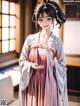 A woman in a pink and white kimono standing in a room.