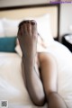 A woman laying on a bed with her feet up.