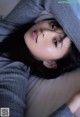 A woman laying on top of a bed under a blanket.