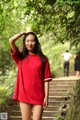 A woman in a red dress standing on some steps.