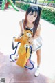 A young woman holding a teddy bear on a swing set.