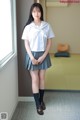 A woman in a school uniform posing for a picture.