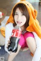 A woman in a bear costume drinking from a bottle.